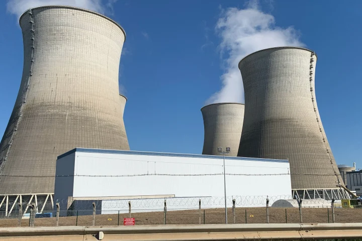 Tours de refroidissement de la centrale nucléaire du Bugey sous un ciel bleu, avec un panache de vapeur